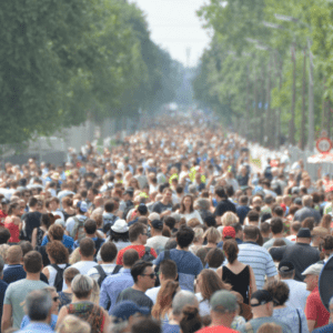 Crowded people in street surrounded by trees